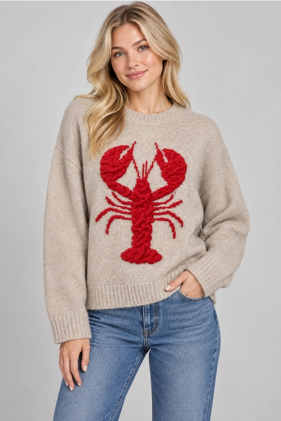 Beige long-sleeve knit sweater with a large textured red lobster, dropped shoulders, and ribbed neckline, cuffs, and hem