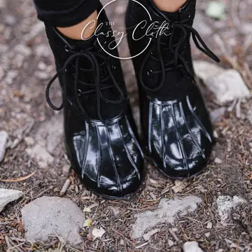Black lace-up duck boots with matching black laces and glossy rounded toes