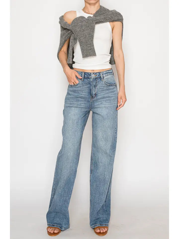 Model wearing faded blue high-rise 90's straight leg jeans with a white top.