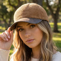 Model wearing a tan corduroy baseball cap with a contrasting brown vegan leather curved brim