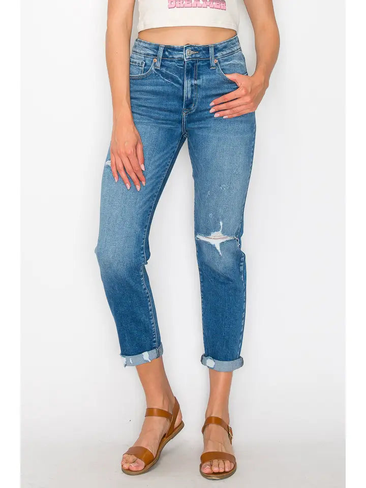 Model wearing faded blue Artemis Vintage mom jeans with distressed details and cuffed hems.