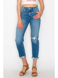 Model wearing faded blue Artemis Vintage mom jeans with distressed details and cuffed hems.