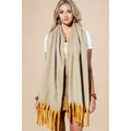 Model wearing a neutral-toned brushed scarf with long mustard-yellow fringed ends