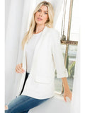 Ivory blazer with notched lapels, front flap-pocket details, and cuffed sleeves styled with a white top and jeans