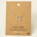 Silver-colored rhodium plated pave sun pendant necklace on a kraft display card