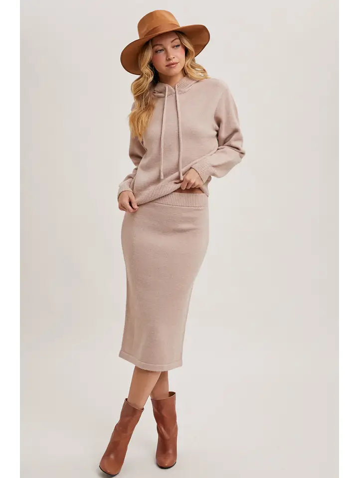 Neutral knit hoodie and midi pencil skirt set styled with brown ankle boots and a wide-brim hat.
