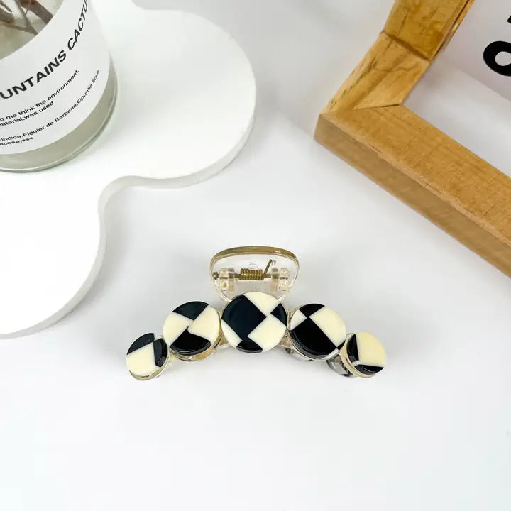 Checkerboard Claw Clip with circular disc teeth in black and cream checkerboard diamond pattern set in silver metal frame