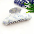 Blue Floral Claw Clip with ditsy blue flowers on white pearlescent base and silver hardware