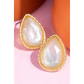 Cream pearlescent-looking teardrop stud earrings with textured gold-tone borders