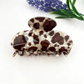 Brown Cow Claw Clip in oversized acetate with classic chocolate brown and cream cow print on pearlescent ivory base