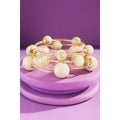Beige and gold marble style bead wrap bracelet set on purple display