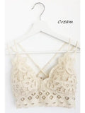 Cream scalloped lace padded bralette with crisscross back straps and floral lace detail, hung on a white hanger