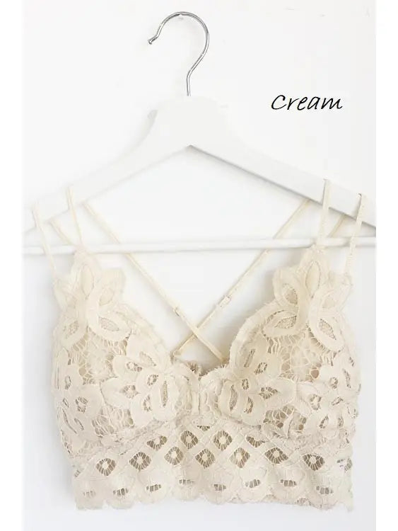 Cream scalloped lace padded bralette with crisscross back straps and floral lace detail, hung on a white hanger
