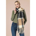 Model wearing a beige, navy, and camel checkered plaid fringe scarf over an olive green top and jeans