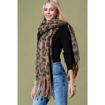 Model wearing a brown and tan leopard print scarf with long fringed ends