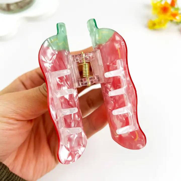Chili Pepper Claw Clip held open showing translucent pearlescent interior and gold spring hardware