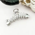 Silver Fishbone Claw Clip sculpted as a full fish skeleton in gleaming chrome silver with detailed rib bones, tail fin, and black eye