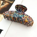 Rainbow Leopard Claw Clip in oversized acetate with all-over rainbow leopard print in teal, red, yellow, purple, and pink on tan base
