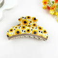 Sunflower Claw Clip in oversized acetate with bright yellow sunflower print and black polka dots on cream white base with silver hardware