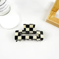 Checkered Hollow Claw Clip in bold black and white checkerboard acetate with rectangular hollow frame silhouette and silver hardware teeth
